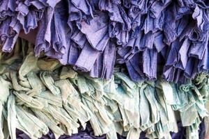 Detailed close up view on samples of cloth and fabrics in different colors found at a fabrics market photo