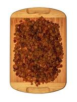 Raisins on a wooden board for the background. Isolated over white background photo