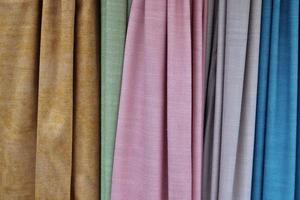 Detailed close up view on samples of cloth and fabrics in different colors found at a fabrics market photo
