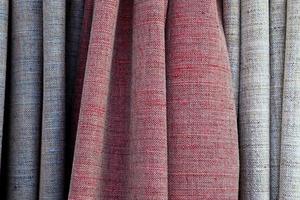 Detailed close up view on samples of cloth and fabrics in different colors found at a fabrics market photo