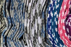 Detailed close up view on samples of cloth and fabrics in different colors found at a fabrics market photo