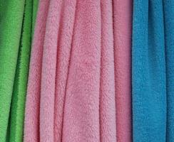 Detailed close up view on samples of cloth and fabrics in different colors found at a fabrics market photo