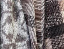 Detailed close up view on samples of cloth and fabrics in different colors found at a fabrics market photo