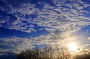 Beautiful view at sunbeams with some lens flares and clouds in a blue sky photo