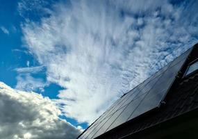 Solar panels producing clean energy on a roof of a residential house photo