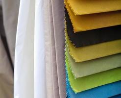 Detailed close up view on samples of cloth and fabrics in different colors found at a fabrics market photo