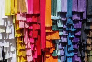 Detailed close up view on samples of zippers in different colors found at a fabrics market photo