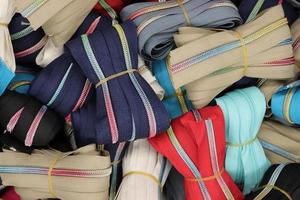 Detailed close up view on samples of cloth and fabrics in different colors found at a fabrics market photo