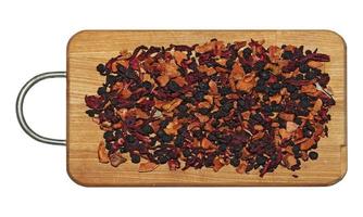 textura de fondo de fragante té negro seco con frutas y pétalos. aislar en una tabla de madera. té con predominio de arándanos secos. foto