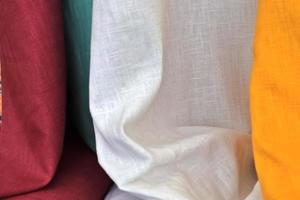 Detailed close up view on samples of cloth and fabrics in different colors found at a fabrics market photo