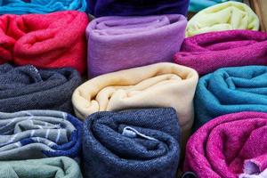 Detailed close up view on samples of cloth and fabrics in different colors found at a fabrics market photo