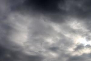 hermosa vista a los rayos de sol con algunas bengalas y nubes en un cielo azul foto