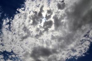 Beautiful view at sunbeams with some lens flares and clouds in a blue sky photo