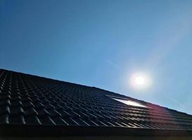 Open roof window in velux style with black roof tiles. photo