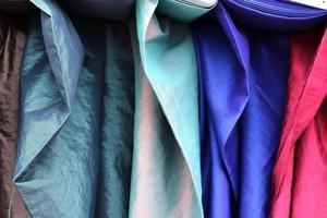 Detailed close up view on samples of cloth and fabrics in different colors found at a fabrics market photo