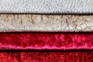 Detailed close up view on samples of cloth and fabrics in different colors found at a fabrics market photo