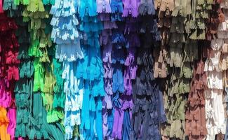 Detailed close up view on samples of zippers in different colors found at a fabrics market photo