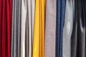 Detailed close up view on samples of cloth and fabrics in different colors found at a fabrics market photo
