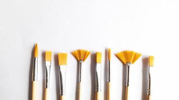 Top view of a variety of artist brushes on a white background with room for text. Creative postcard photo