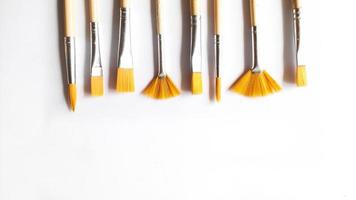 Top view of a variety of artist brushes on a white background with room for text. Creative postcard photo