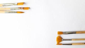 Top view of a variety of artist brushes on a white background with copy space for text. Creative postcard photo