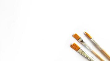 Top view of a variety of artist brushes on a white background with copy space for text. Creative postcard photo