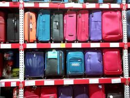 Many modern suitcases on shelves at wholesale market photo