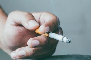 close up smoking Cigarettes in hand Smoke spread with a soft-focus. photo