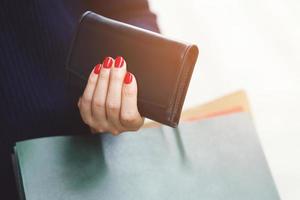 mujer persona sosteniendo una billetera en la mano. gastos de control de costes compras en concepto. deje espacio para escribir texto descriptivo. foto