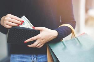 woman person holding a wallet in the hand of a  take money out of pocket. Cost control expenses shopping in concept. Leave space to write descriptive text. photo