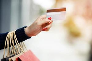 woman person holding a wallet in the hand of a  take credit card out of pocket. Cost control expenses shopping in concept. Leave space to write descriptive text. photo