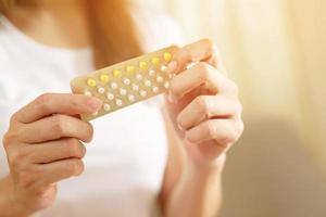 Woman hands opening birth control pills in hand. eating Contraceptive pill. Contraception reduces childbirth and pregnancy concept. Leave space to write descriptive text. photo