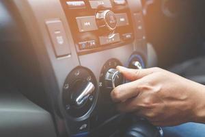 Closeup of hand driver man checking switch adjusting air from conditioning the cooling system with flow of cold in car. Leave space for writing text. photo