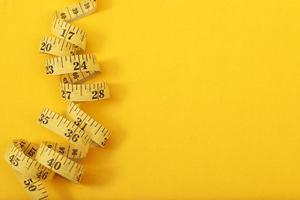 tape measure for obese people on a yellow background soft focus photo