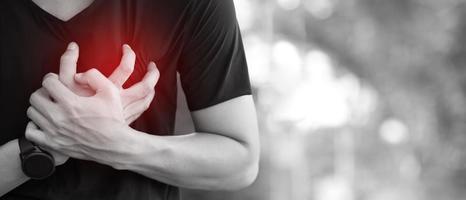 hombre con dolor de pecho - ataque al corazón al aire libre. o el ejercicio pesado hace que el cuerpo sufra enfermedades del corazón foto