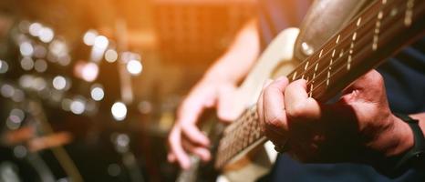 close up hand young man playing electric guitar at recording studio rehearsal base. rock music band. photo