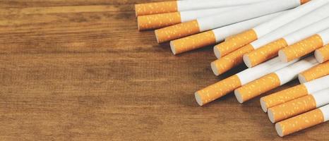 imagen de varios cigarrillos fabricados comercialmente. pila de cigarrillos en madera. o concepto de campaña para no fumadores, tabaco foto