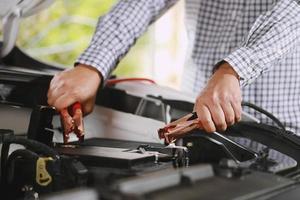 A mechanic  is charging car battery pot photo