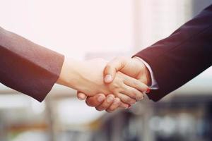 Closeup of a businessman hand shake businesswoman between two colleagues  OK, succeed in business Holding hands. photo