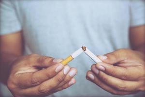 Man refusing cigarettes concept for quitting smoking and healthy lifestyle.or No smoking campaign Concept. black dark background. photo