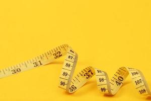 cinta métrica para personas obesas con un enfoque suave de fondo amarillo