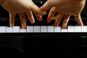 close up of hand people man musician playing piano keyboard with selective focus keys. can be used as a background. photo