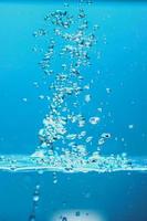 Abstract background image of bubbles in water. Clean water with water droplets and waves. Fresh water a glass with bubbles blue background. photo