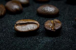 The way coffee beans lay on a black background, elegant and delicious coffee beans and the aroma of morning coffee. photo