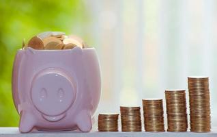 Business Finance and Money concept,with Piggy bank,Save money for prepare in the future.tree growing on coin of stacking gold coins with green bokeh background photo