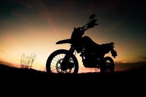 Tourist motorcycle motocross silhouette Park on the mountain in the evening. adventure travel concept photo