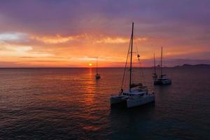 vista aérea desde drones en barcos que se envían al mar, puesta de sol foto