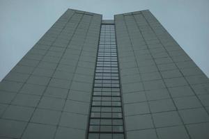 High-rise building on gray day. Architecture details. Surface of wall. photo