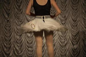 White tutu at the ballerina. Girl's dance. Performance in the theater. Stage clothes. Dance movement. photo