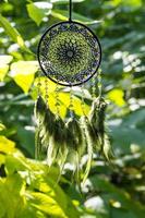 atrapasueños hecho a mano con hilos de plumas y cuerda de cuentas colgando foto